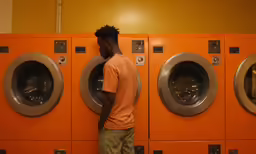there is a black man standing in front of the washers