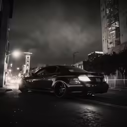 a car parked at night in front of a large clock tower