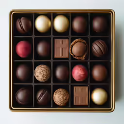chocolates and apples in a box on a white background