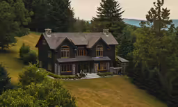 a large house with an elevated deck sitting above the trees