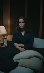 a woman laying on a bed in the dark