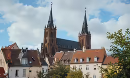 old buildings with steeple tops and spires against blue sky