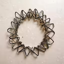 a spiral sculpture made of metal sitting on top of a wall
