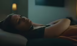a woman laying in bed with eyes closed