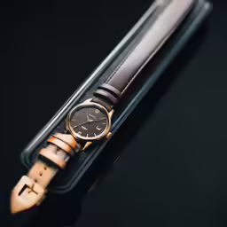 an automatic watch sits on top of a leather case