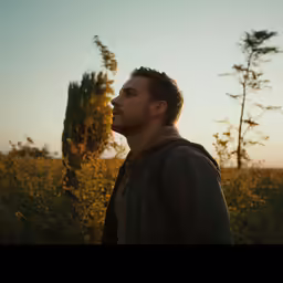 the man is standing in front of some flowers