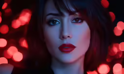 a woman with dark makeup and red lipstick, wearing a black top
