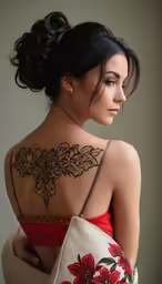 a woman is posing for a picture with her back tattoo
