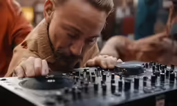 a dj playing a set up in front of two other djs