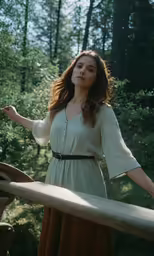 a beautiful young woman standing in front of trees