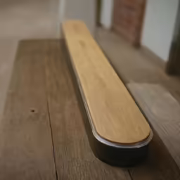 a wooden bench with an odd shaped metal leg rest