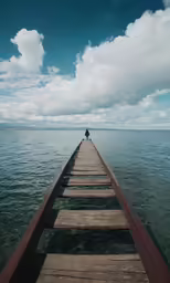 a person sitting on a pier over a body of water