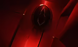 a lighted clock is lit up in a red room