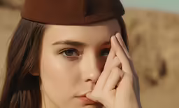 the young girl has her face near her forehead