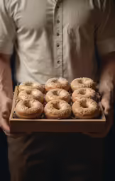 a person holding a box of donuts with some frosting on them