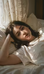 a girl laying in bed and looking up