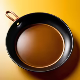 a black skillet on a yellow surface