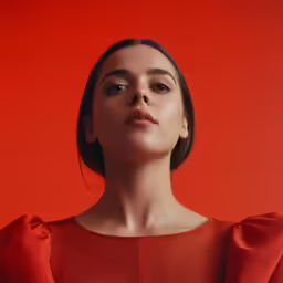 woman in red dress posing on red background