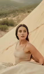 a girl wearing beige poses in sand dunes