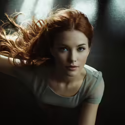 a young girl with long red hair laying on her back