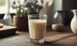 the glass of milk is next to some lavenders