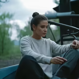a woman in a sweatshirt sitting down outside