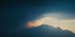 a bird that is flying in the air over a mountain
