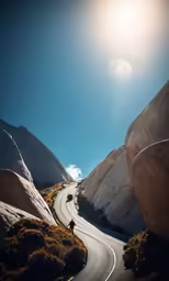 a person riding down a road near the mountains