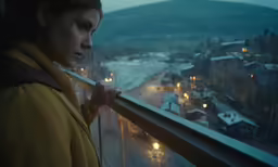a girl looks out over the city at night