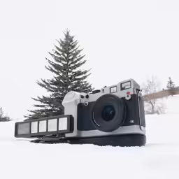 an old camera sitting on top of snow covered ground