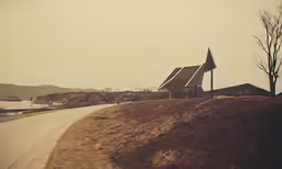 a road with a church shaped building and trees next to it