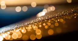 blurred gold and white background with lots of water drops