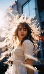 a woman is walking with her hair blowing in the wind