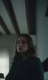 the woman is standing in a dark room