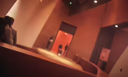 two people look out a door as they walk into a bathroom