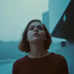 a woman wearing red is looking up at something