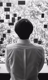 a person with a white bow tie looks at a display of confetti on the wall