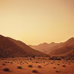 a scenic view of mountains and desert terrain at sunset