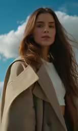 a beautiful young woman in a white top is holding her long hair