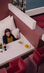 a child in bed with a plate of food, cup and spoon, and one with a fork