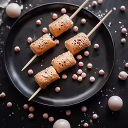 a plate topped with mini meat loaves next to pink eggs