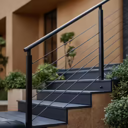 a set of metal stairs and planters on concrete steps outside an apartment building