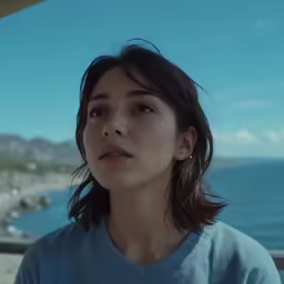 a young woman standing in front of an ocean
