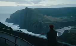 a person standing on the cliff above the water