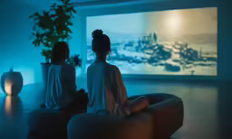 two girls are sitting in a dimly lit room