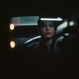 a man sitting in a car with light coming from his eyes