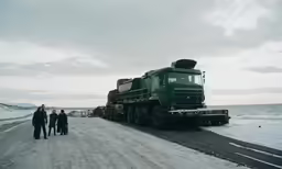 a large truck on a road near the ocean