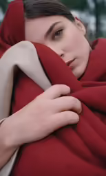 a girl with an orange jacket wrapped around her head