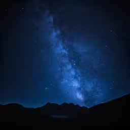 a large star filled sky over a mountain range