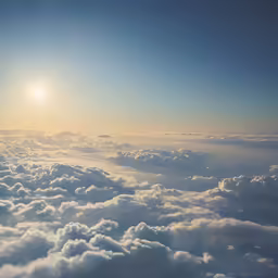 a plane flying in the sky above a large group of clouds